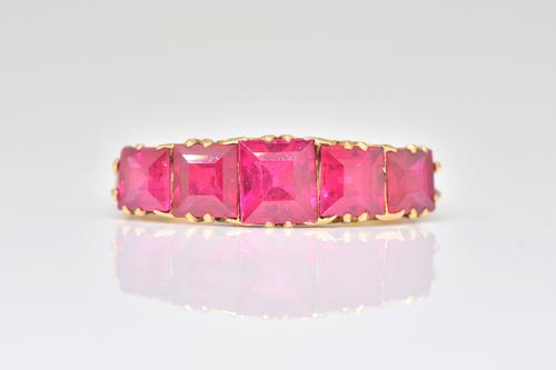 A GOLD AND SYNTHETIC RED GEM SET FIVE STONE RING