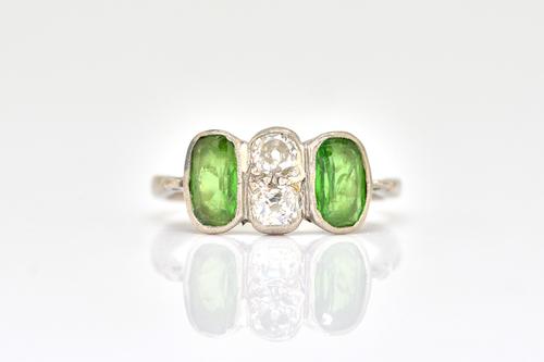 A PLATINUM, DIAMOND AND GREEN GEMSTONE SET RING