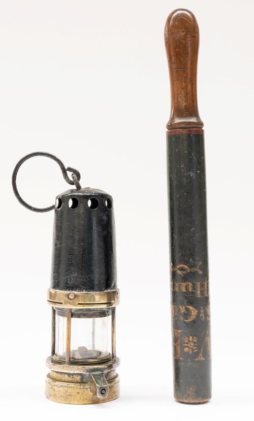 A VICTORIAN EBONISED POLICE TRUNCHEON AND A MINER’S LAMP (2)