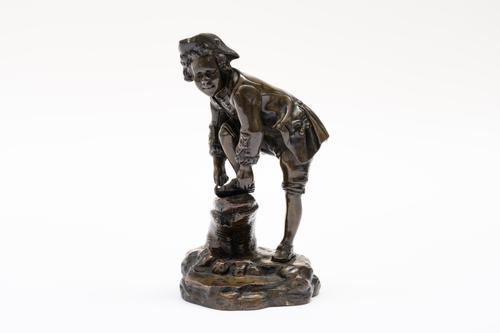 A FRENCH BRONZE FIGURE OF A BOY WITH AN ICE SKATE