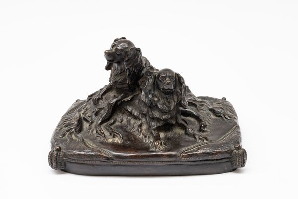 A BRONZE GROUP OF TWO KING CHARLES SPANIELS SEATED ON A CUSHION