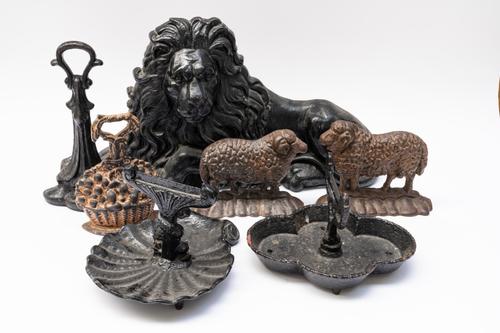 A GROUP OF FIVE CAST-IRON DOOR STOPS AND TWO BOOT SCRAPERS