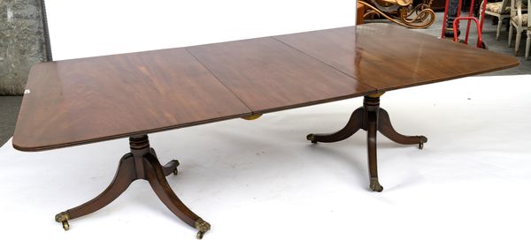 A REGENCY STYLE MAHOGANY TWIN PEDESTAL EXTENDING DINING TABLE