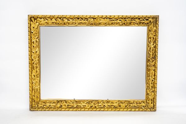 A 20TH CENTURY GILT FRAMED MIRROR WITH DEEP CARVED FLORAL FRAME