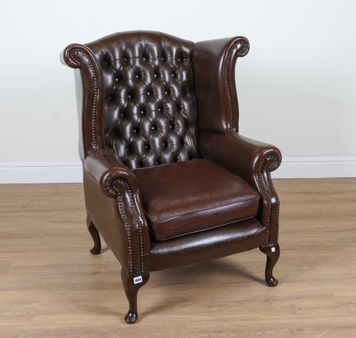 AN EARLY 18TH CENTURY STYLE STUDDED BROWN LEATHER UPHOLSTERED WINGBACK ARMCHAIR