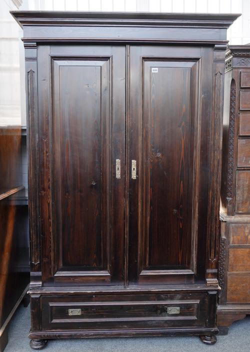 A CONTINENTAL STAINED PINE TWO DOOR ARMOIRE