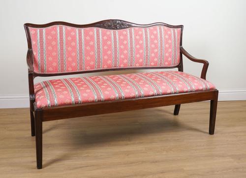 AN 18TH CENTURY STYLE CARVED MAHOGANY FRAMED OPEN ARM SETTEE ON TAPERING SQUARE SUPPORTS