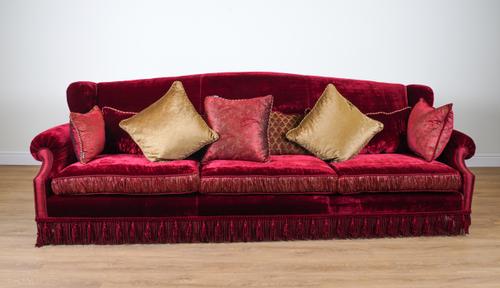 PROVASI: A LARGE RED VELVET AND PAISLEY SILK UPHOLSTERED WINGBACK SOFA