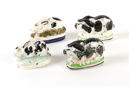 FOUR SMALL STAFFORDSHIRE POTTERY BLACK AND WHITE RABBITS (4)