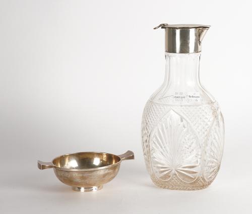 A SILVER TWIN HANDLED BOWL AND A SILVER MOUNTED FACETED GLASS CLARET JUG (2)