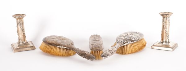 A PAIR OF SILVER CANDLESTICKS AND THREE SILVER MOUNTED BRUSHES (5)