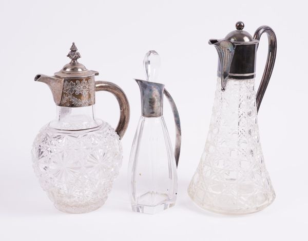 A LATE VICTORIAN SILVER MOUNTED CLARET JUG AND TWO FURTHER PLATED METAL MOUNTED JUGS (3)