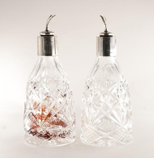 A PAIR OF SILVER MOUNTED FACETED GLASS BITTER'S BOTTLES (2)