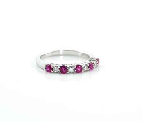 A WHITE GOLD, RUBY AND DIAMOND NINE STONE HALF ETERNITY RING