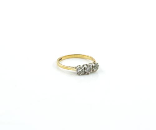 AN 18CT GOLD AND DIAMOND THREE STONE RING