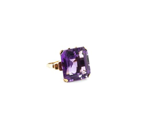 A GOLD AND AMETHYST SINGLE STONE RING