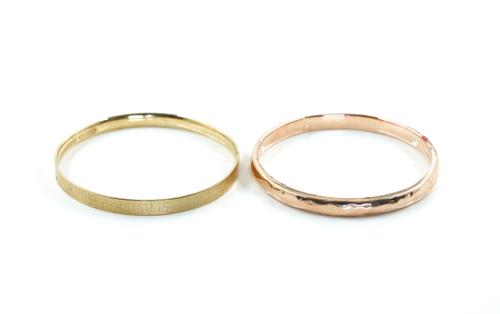 A GOLD BANGLE AND A GILT METAL BANGLE (2)