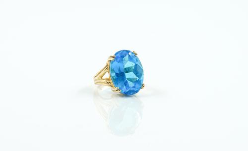 A GOLD AND BLUE TOPAZ SINGLE STONE RING