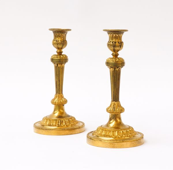 A PAIR OF LOUIS XVI ORMOLU CANDLESTICKS (2)