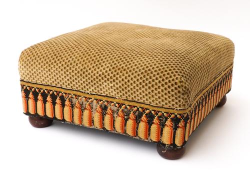 A FOOT STOOL WITH WOOL EMBROIDERED TASSELS