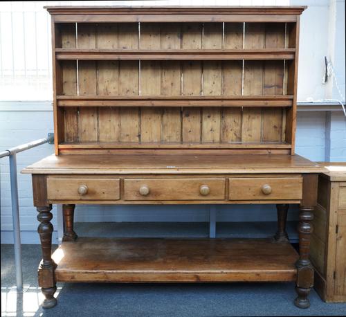 A PINE DRESSER WITH ENCLOSED BACK OVER POTBOARD THREE DRAWER BASE