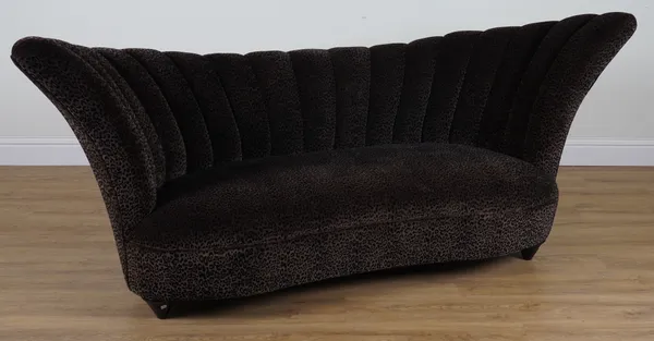 A LEOPARD PRINT TWO SEATER WING-BACKED SOFA