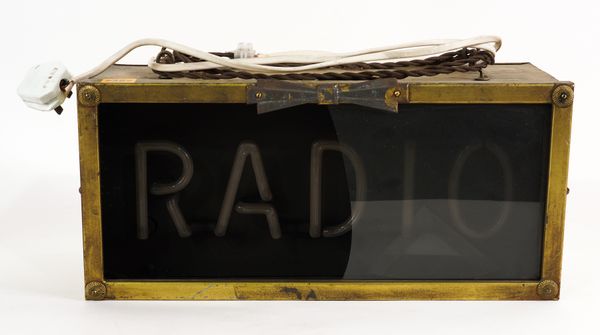 A MID 20TH CENTURY NEON “RADIO” SIGN, IN A BRASS CASE