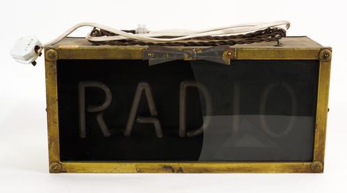 A MID 20TH CENTURY NEON “RADIO” SIGN, IN A BRASS CASE