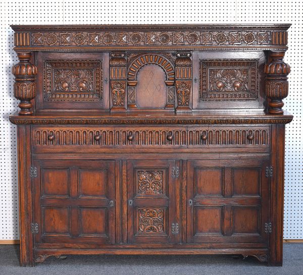 A 17TH CENTURY STYLE CARVED OAK COART CUPBOARD