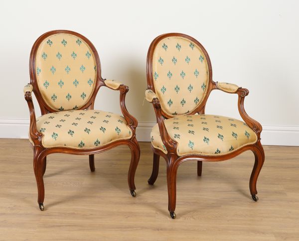 A PAIR OF 19TH CENTURY WALNUT FRAMED OVAL BACK OPEN ARMCHAIRS (2)