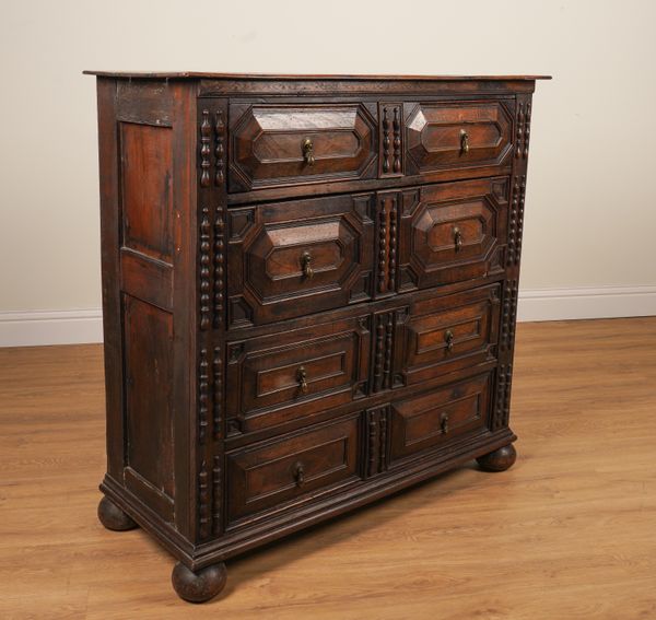 A CHARLES II STYLE OAK GEOMETRIC MOULDED FOUR DRAWER CHEST OF DRAWERS