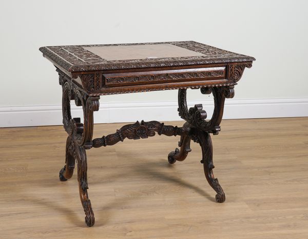 A 19TH CENTURY ANGLO-INDIAN EXTENSIVELY CARVED TEAK SINGLE DRAWER SIDE TABLE WITH INSET CHESSBOARD TOP