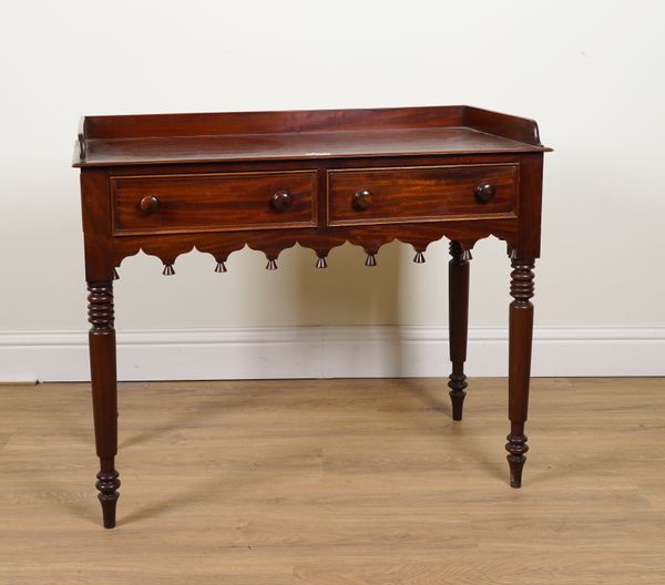 A 19TH CENTURY MAHOGANY TWO DRAWER WRITING DESK WITH SHAPED FRIEZE