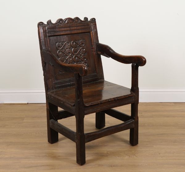 A 17TH CENTURY AND LATER OAK CARVED PANEL BACK WAINSCOTT OPEN ARMCHAIR