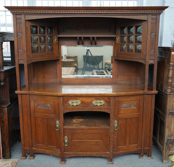 LIBERTY’S; AN OAK ARTS AND CRAFTS MIRROR BACK DRESSER WITH AN ARRANGEMENT OF CUPBOARDS AND DRAWERS