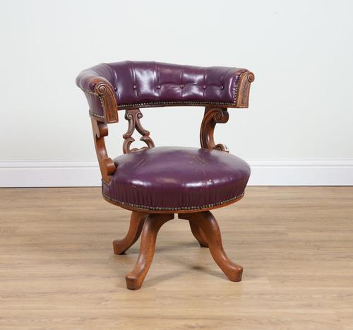 A VICTORIAN CARVED MAHOGANY FRAMED ROUGE LEATHER UPHOLSTERED TUB BACK SWIVEL DESK CHAIR