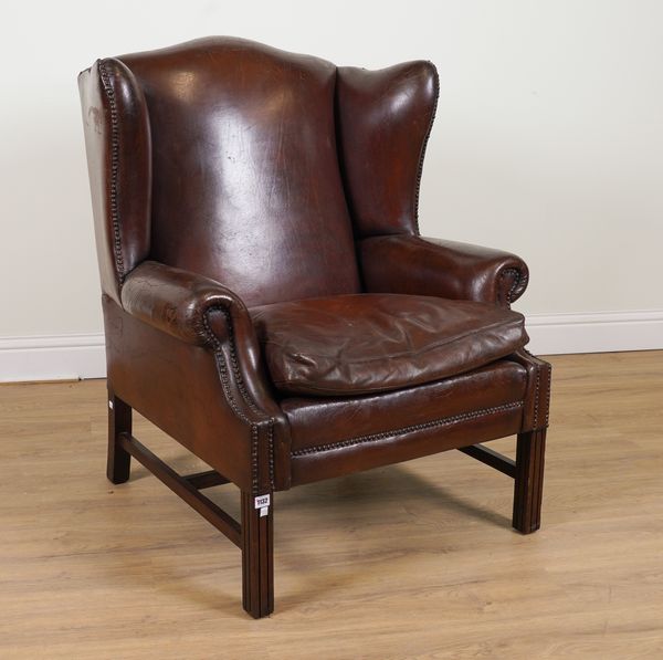 A GEORGE II STYLE STUDDED TAN LETAHER UPHOLSTERED WINGBACK ARMCHAIR