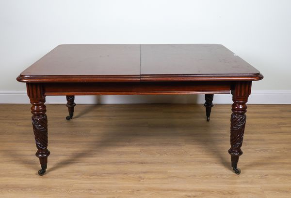 A MAHOGANY EXTENDING DINING TABLE ON CARVED SPIRAL FLUTED SUPPORTS