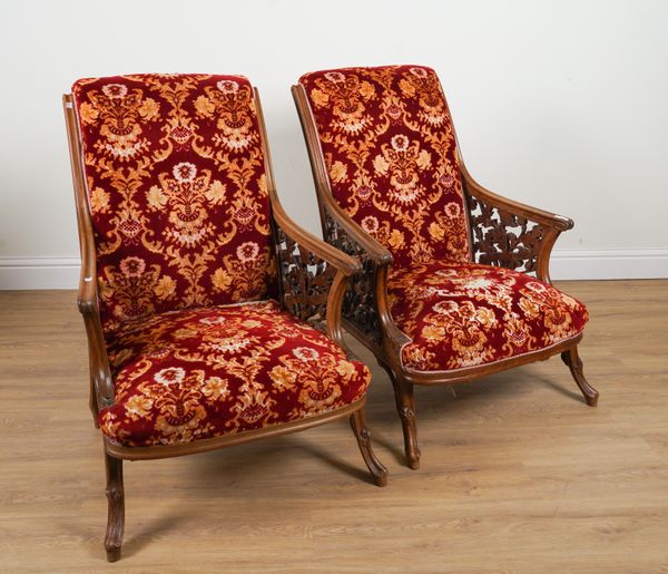 A PAIR OF EARLY 20TH CENTURY MAHOGANY FRAMED OPEN ARMCHAIRS WITH CARVED AND PIERCED FOLIATE SIDES (2)