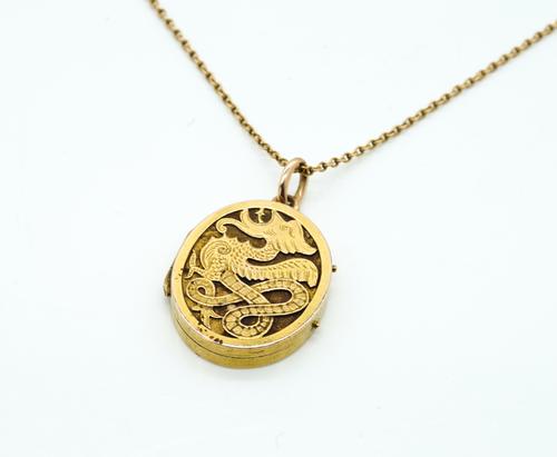 A GOLD MOUNTED OVAL PENDANT LOCKET WITH A GOLD NECKCHAIN (2)