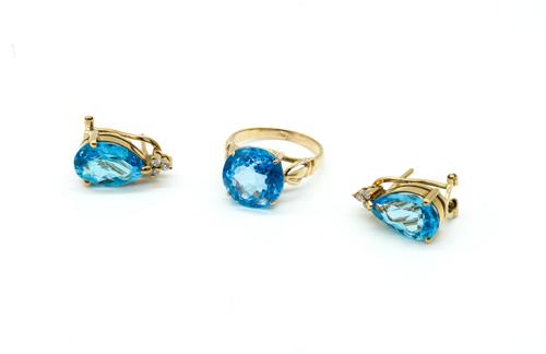 A GOLD AND TREATED BLUE TOPAZ SOLITAIRE RING AND A PAIR OF TREATED BLUE TOPAZ AND DIAMOND EARRINGS (2)