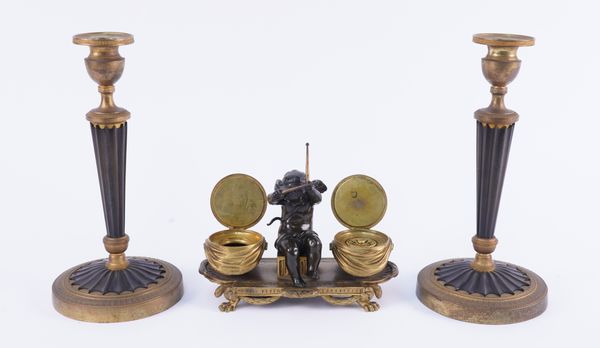 A PAIR OF FRENCH LOUIS XVI STYLE GILT AND BRONZE PATINATED CANDLESTICKS AND A CHERUB DRUMMER ENCRIER (3)