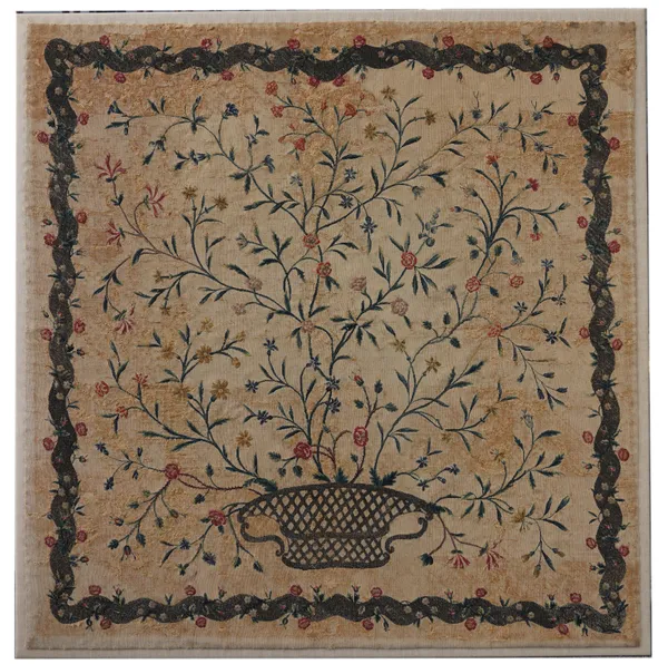 A NEEDLE POINT EMBROIDERED PANEL DEPICTING A FLORAL SPRAY ISSUING FROM A WOVEN BASKET