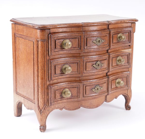 A 19TH CENTURY OAK MINIATURE THREE DRAWER COMMODE ON SCROLL FEET