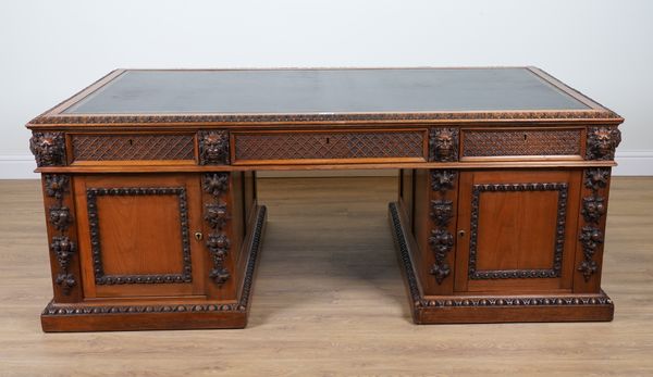 A 19TH CENTURY OAK PEDESTAL PARTNERS’ DESK WITH THREE DIAMOND TRELLIS CARVED FRIEZE DRAWERS DIVIDED BY LION MASK MOUNTS OVER PEDESTALS