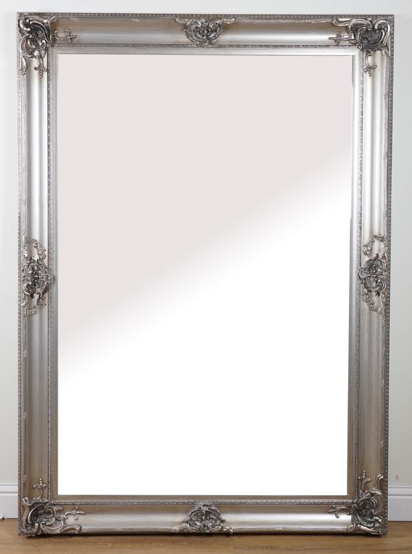 A LARGE SILVER PAINTED WALL MIRROR WITH BEVELLED PLATE AND RELIEF 'C' SCROLL MOUNTS