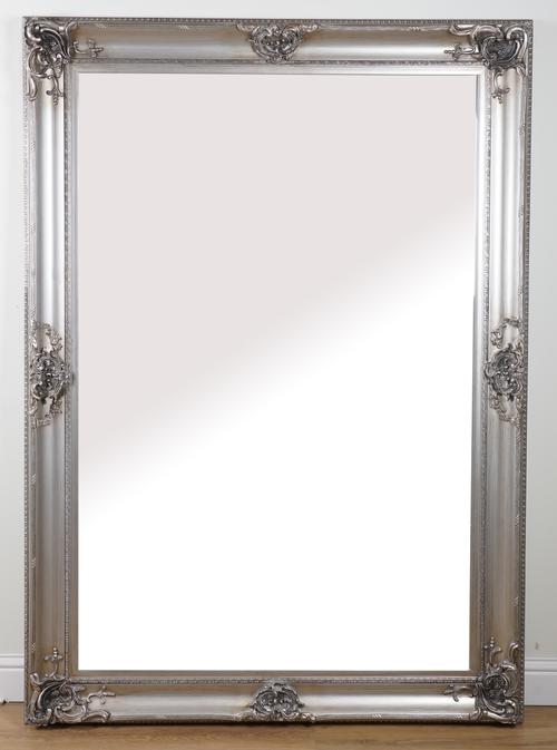 A LARGE SILVER PAINTED WALL MIRROR WITH BEVELLED PLATE AND RELIEF 'C' SCROLL MOUNTS