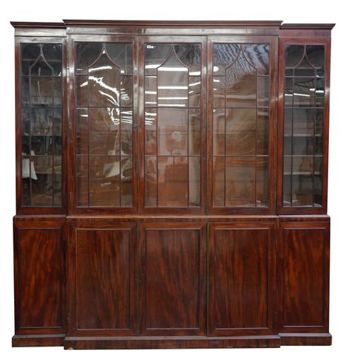 A GEORGE III MAHOGANY BREAKFRONT BOOKCASE CABINET WITH FIVE ASTRAGAL GLAZED DOORS OVER PANELLED CUPBOARDS ON PLINTH BASE