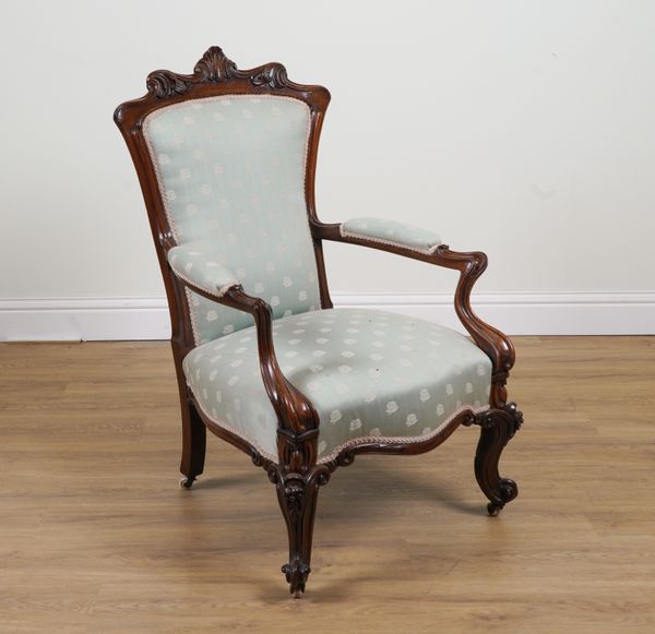 A VICTORIAN CARVED AND SHAPED ROSEWOOD FRAMED OPEN ARM EASY CHAIR