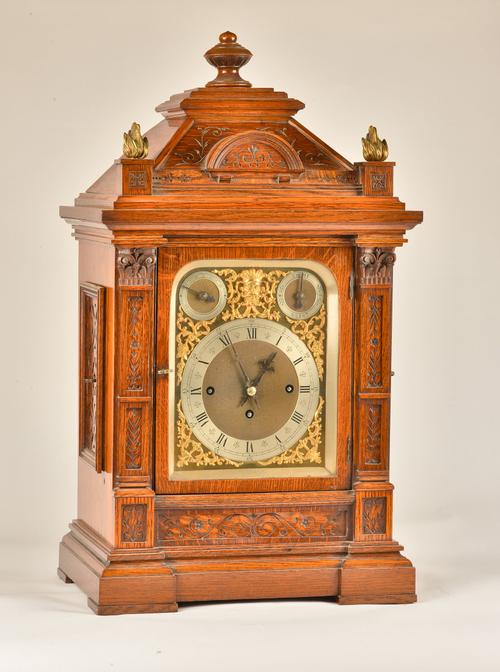 A LATE VICTORIAN OAK CASED QUARTER CHIMING MANTEL CLOCK
